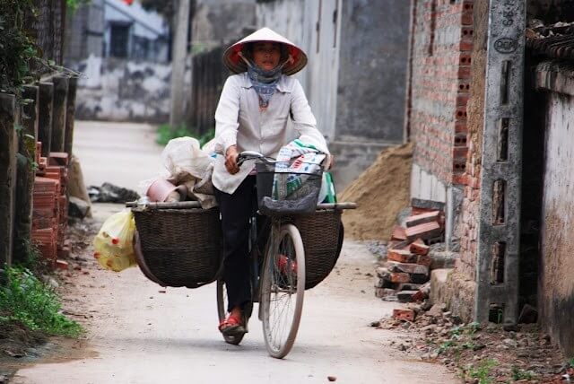 Une femme transporte ses marchandises sur son vélo...
